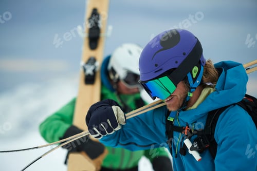 Preview: Two male skiers carrying skis in snow, Alpe-d'Huez, Rhone-Alpes, France