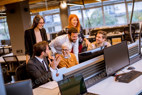 Preview: Senior businesswoman working together with young business people in modern office