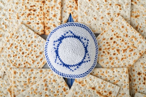 Preview: Passover celebration concept. White kippah with Star of David on Matzah texture background. Passover
