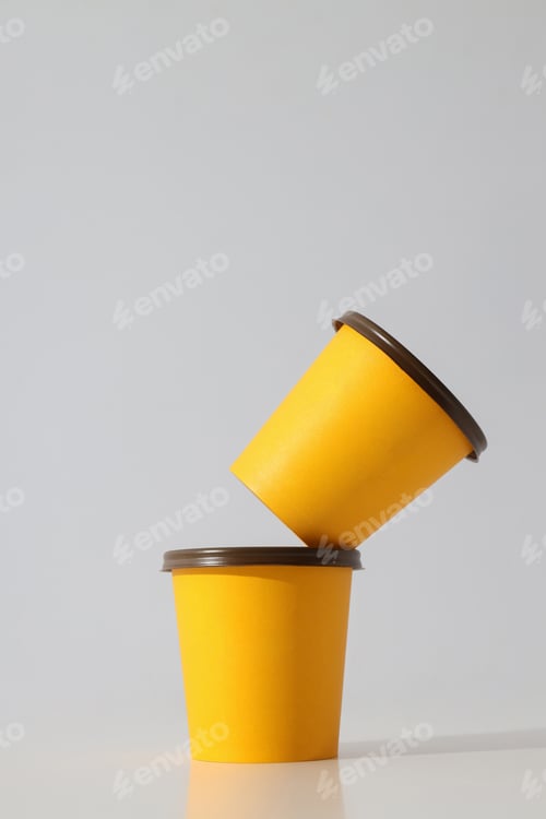 Preview: Yellow paper cups with lids on a light background
