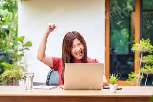 Preview: Asian business woman using technology laptop and celebrating when job success