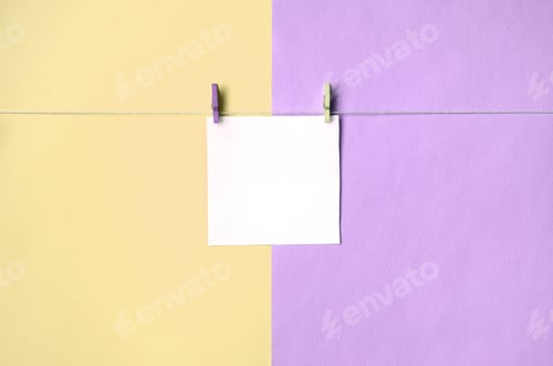 Preview: A piece of paper is hanging on a rope with pegs on texture background of fashion pastel yellow and