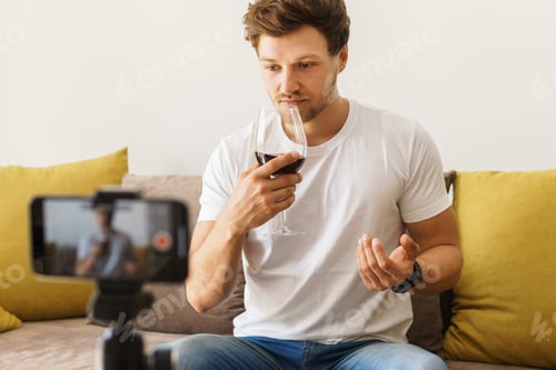 Preview: Sommelier blogger on sofa is smelling red wine