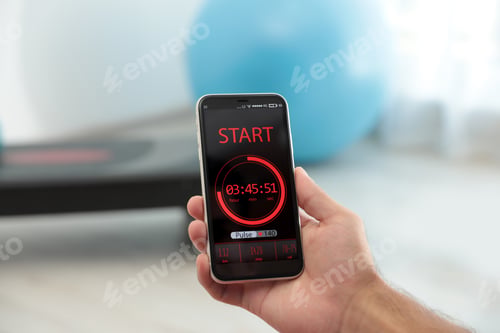 Preview: Man using fitness app on smartphone indoors, closeup