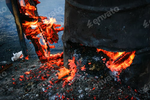 Preview: Vertical shot of burning garbage in a rusty iron metal container