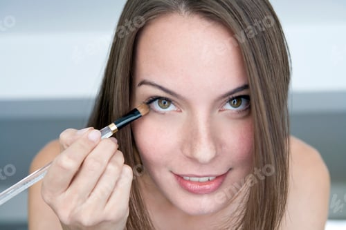 Preview: Young woman applying eye shadow, portrait,, close-up