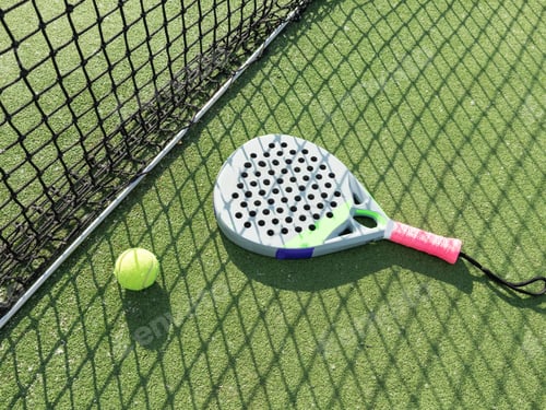 Preview: Paddle tennis racket, ball and net on the grass