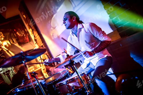 Preview: Drummer playing on drum set on stage.
