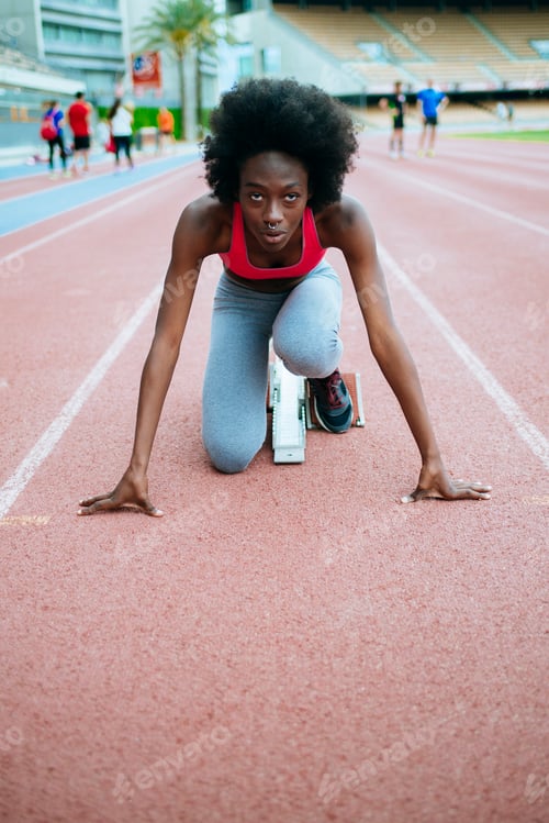 Preview: Determined female athlete preparing for race on track