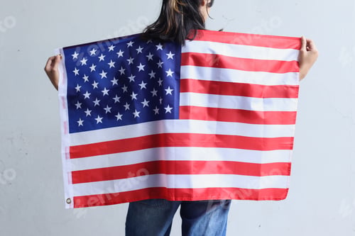 Preview: Young woman stands and holds an American flag