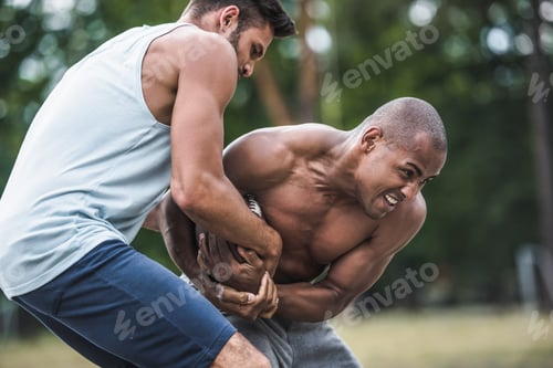 Preview: group of young multicultural men playing football on court