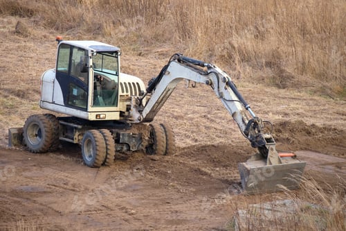 Preview: Earth moving tractor preparing place for future house foundation construction.