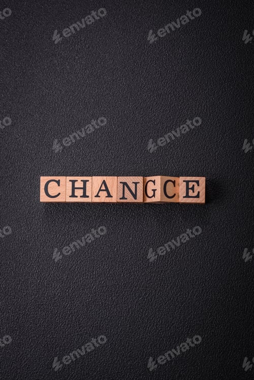Preview: The inscription chance or change with wooden cubes on a dark concrete background