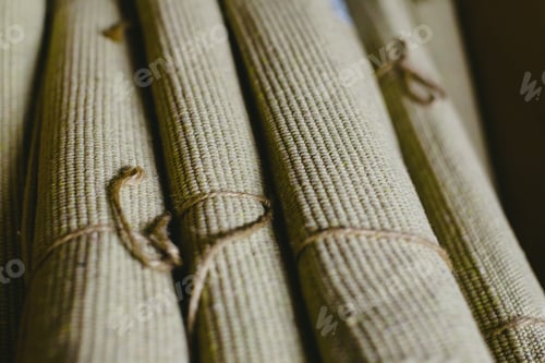 Preview: Many brown carpets rolled up in a warehouse for sale.
