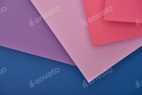 Preview: top view of lilac, violet, blue and pink paper sheets with copy space
