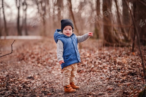 Preview: Little toddler boy in autumn outfit walking in parks in fall with fallen leaves