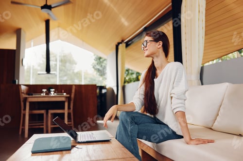 Preview: Smiling Woman Using Laptop on Sofa in Home Office Education and Connection in the Digital World