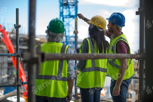 Preview: Construction worker talking to man and woman on a construction site