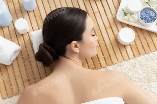 Preview: Brunette woman on massage, jars with body cream, wooden background