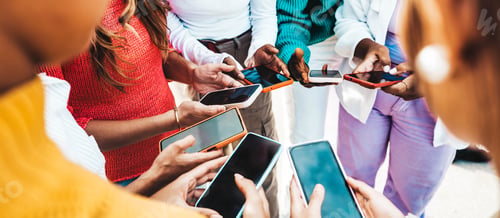 Preview: Group of multiracial young people using smart mobile phone device outdoors
