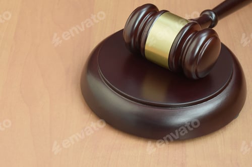 Preview: Justice mallet on wooden desk in a courtroom during a judicial trial
