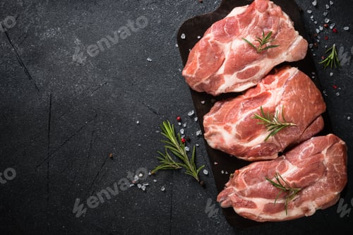 Preview: Fresh steaks with herbs and spices at black background.