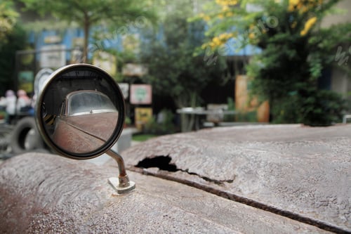 Preview: round rear view mirror of a rusty old car