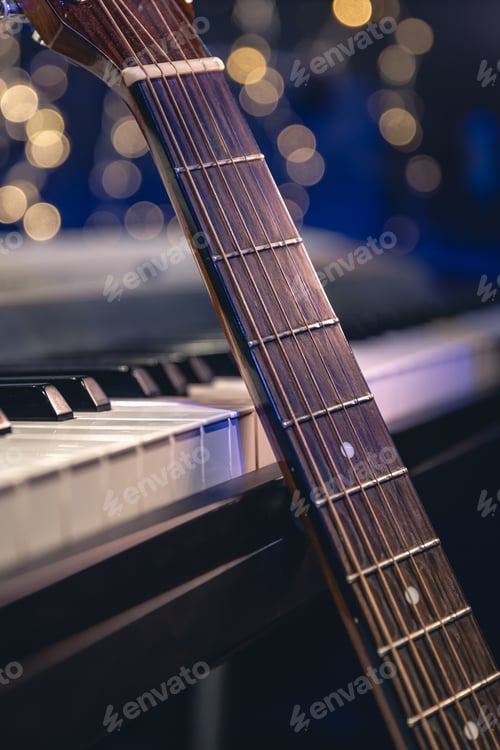 Preview: Guitar and piano keys close-up on a blurred background with bokeh.