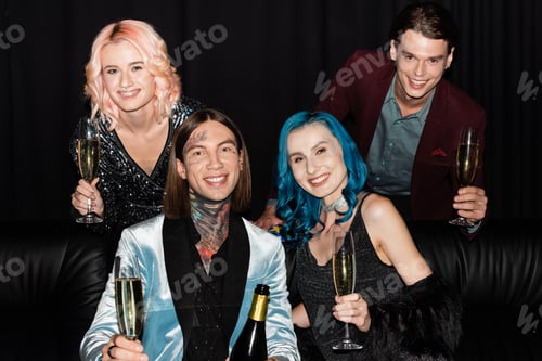 Preview: cheerful nonbinary people in festive clothes celebrating christmas with champagne and looking at