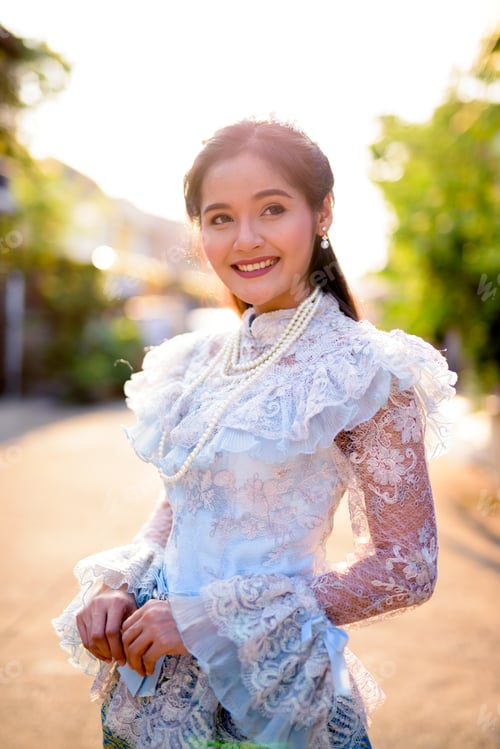 Preview: Young beautiful Asian woman wearing Thai traditional clothes outdoors