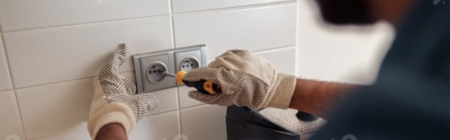 Preview: Close up of professional electrician worker with screwdriver is repairing power socket in kitchen