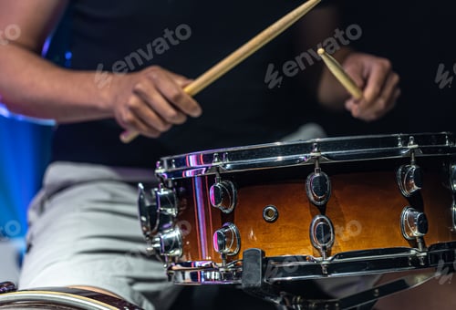 Preview: Close-up shot of a drummer playing a snare drum with sticks.