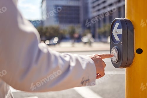 Preview: Always cross the road safely. Shot of a businessman pressing a button at a crosswalk in the city.