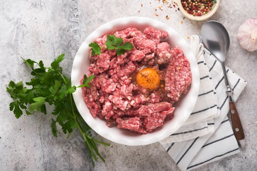 Preview: Raw minced meat. Ground meat beef, pork or lamb spices, herbs and eggs on white plate on light grey