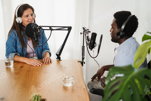 Preview: Multiracial hosts streaming podcast together at record studio - Focus on woman microphone