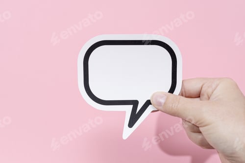 Preview: Hand holding a blank speech bubble isolated on pink background. Template Mockup