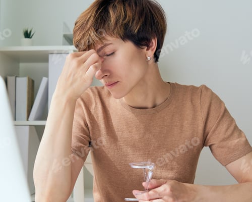 Preview: Woman with Headache Holding Glass of Water