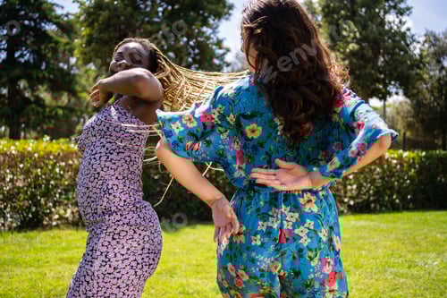 Preview: Couple of women of different ethnicities dancing energetically outdoors