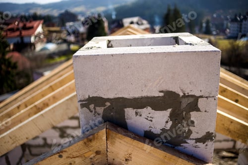 Preview: Close-up detail of roof frame of rough wooden lumber beams and chimney made of foam insulation