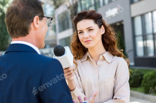 Preview: beautiful journalist with microphone interviewing professional businessman