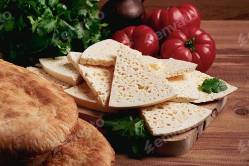 Preview: Georgian sliced cheese,on a wooden chopping board, with tomatoes with herbs and lavash,