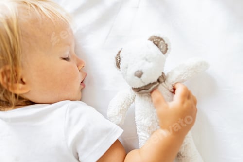 Preview: Cute little baby from behind wearing white clothing and sleeping on stomach with open mouth