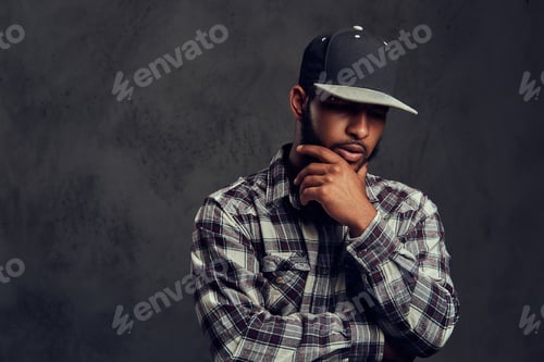 Preview: African-American bearded guy wearing a checkered shirt and cap