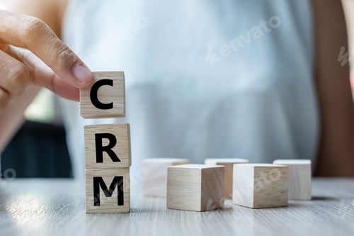 Preview: Business woman hand holding wooden cube with CRM text (Customer Relationship Management)