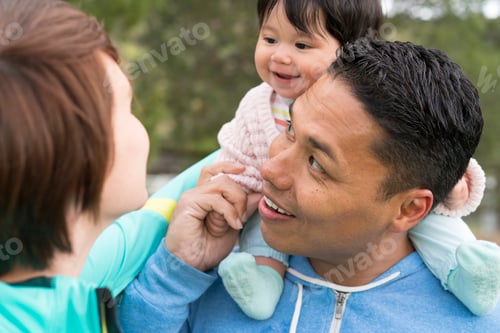 Preview: Couple playing piggyback ride with baby in park