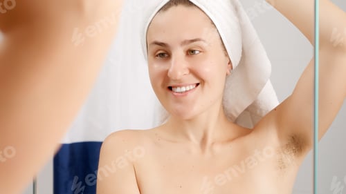 Preview: Young woman after having shower feeling bad smell and applying deodorant. Concept of hygiene,natural