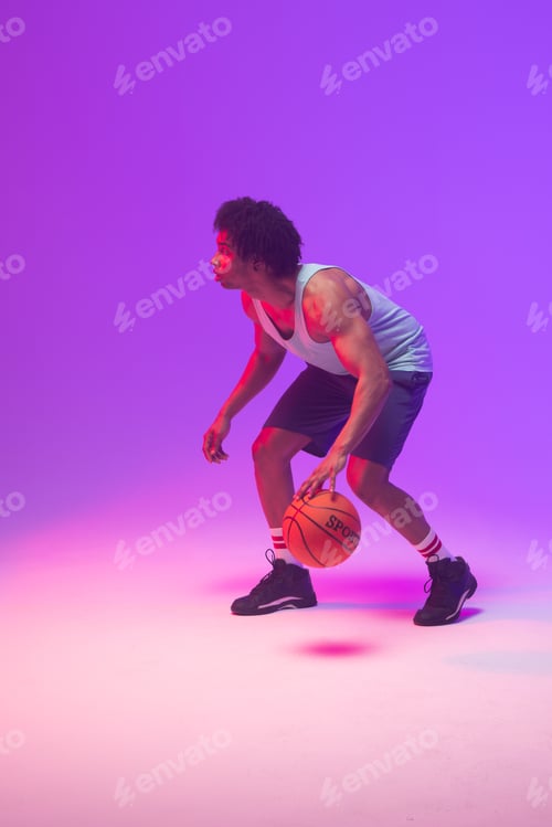 Preview: Image of biracial basketball player bouncing basketball on neon purple background