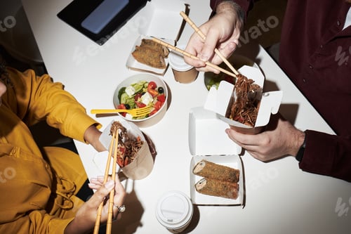 Preview: Multiethnic Colleagues Sharing Takeout Noodles and Salad during Lunch Break