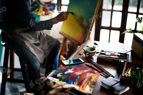 Preview: Artist painting artwork at workspace
