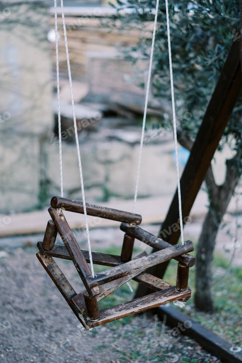 Preview: Wooden old swing with a broken seat in the garden